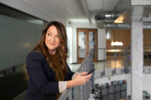 a woman leaning on a railing inside an office building